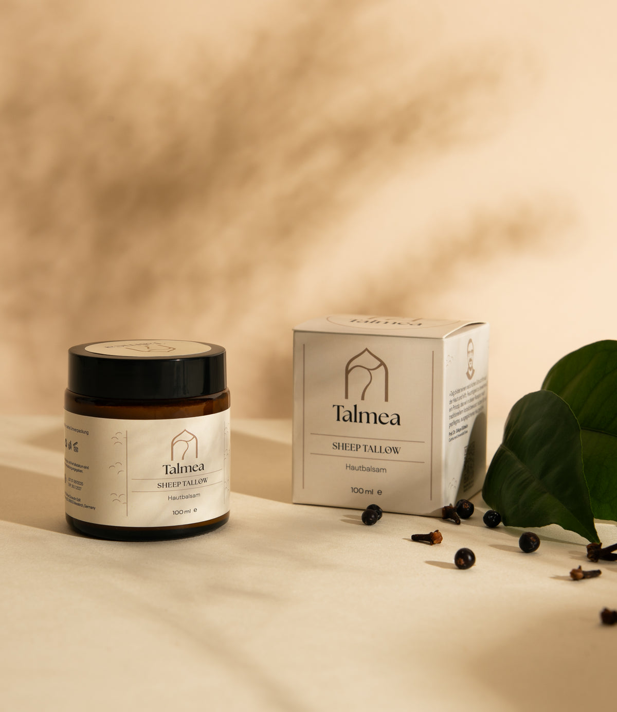 Talmea Sheep Tallow 100 ml mit Verpackung und grünen Blättern auf neutralem Hintergrund