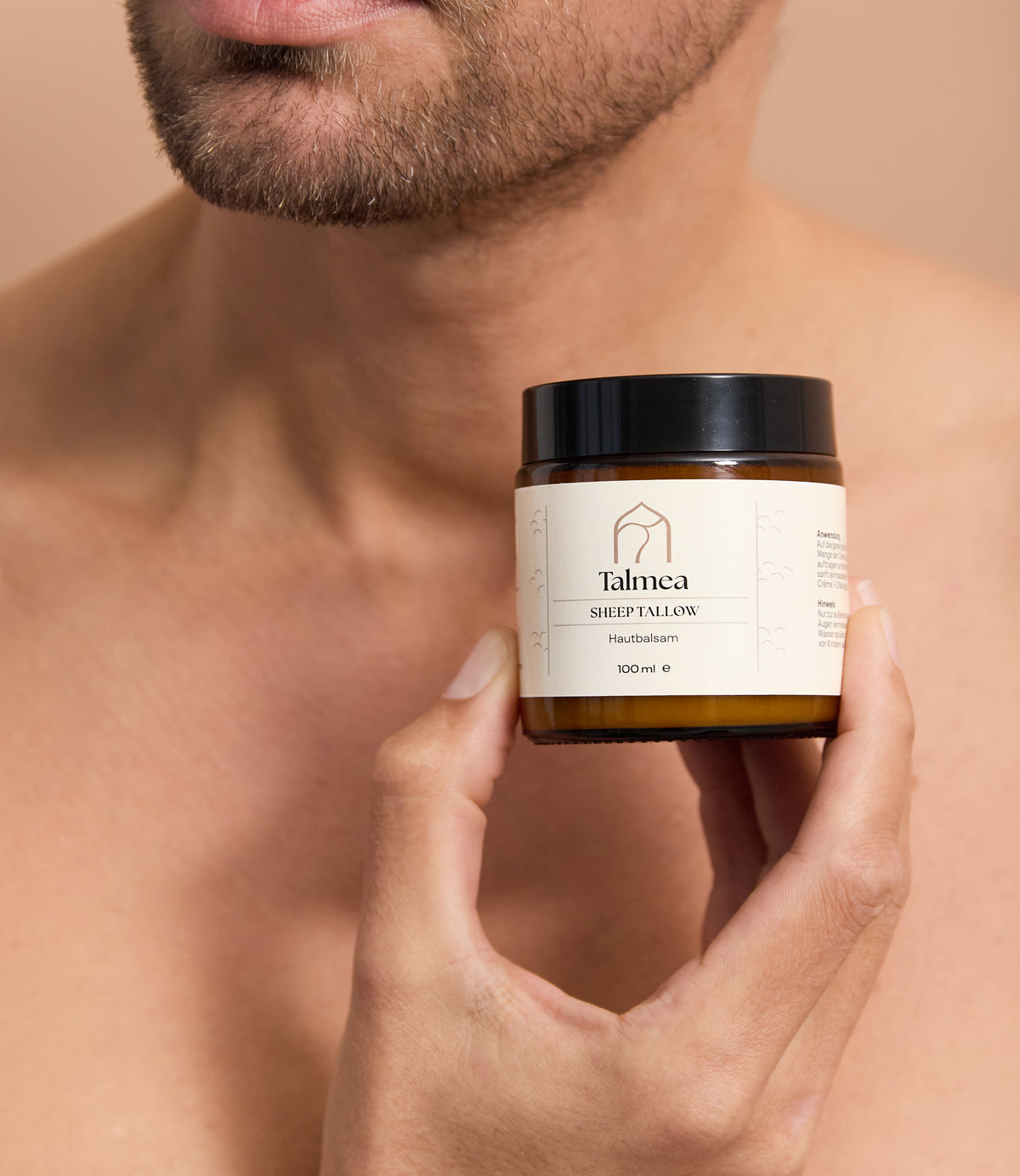 Mann hält Talmea Sheep Tallow Creme 100 ml vor Brust